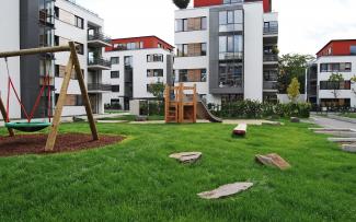The foundations for the playground equipment are made by concreting the drainage elements, which then act as lost formwork and continue to ensure good drainage. Residential complex with lawn and playground